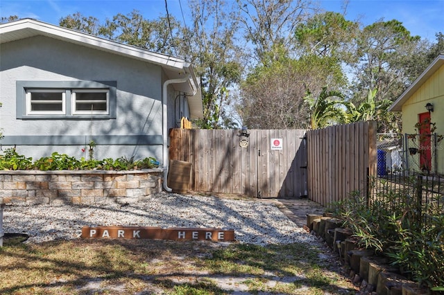 view of side of property featuring fence and stucco siding