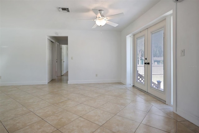 spare room with french doors, visible vents, light tile patterned flooring, ceiling fan, and baseboards