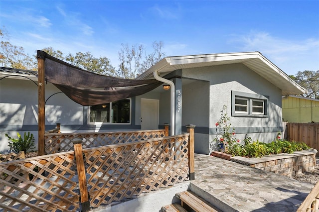 view of front of property featuring fence and stucco siding