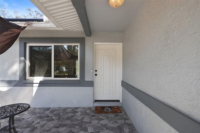 entrance to property featuring stucco siding