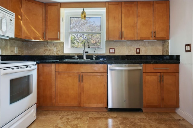 kitchen featuring tasteful backsplash, brown cabinetry, a sink, dark stone counters, and white appliances