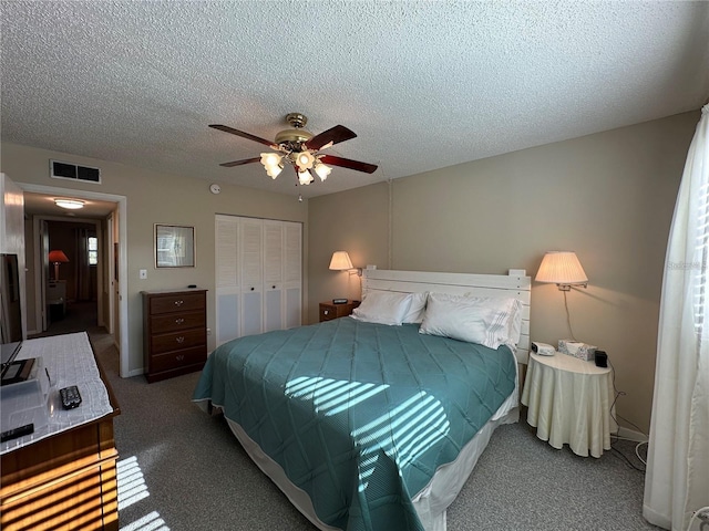 carpeted bedroom featuring ceiling fan, a closet, and a textured ceiling