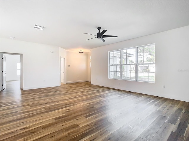 unfurnished living room featuring ceiling fan and dark hardwood / wood-style floors