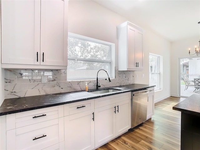 kitchen featuring sink, dishwasher, hanging light fixtures, white cabinets, and decorative backsplash