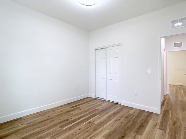 unfurnished bedroom with hardwood / wood-style flooring and a closet