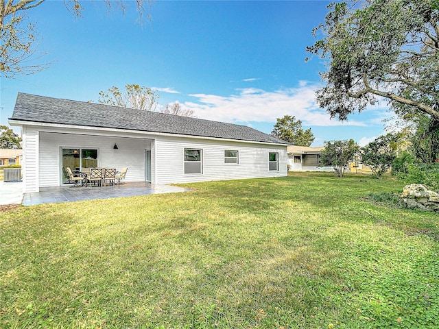 rear view of property with a yard, central AC unit, and a patio area