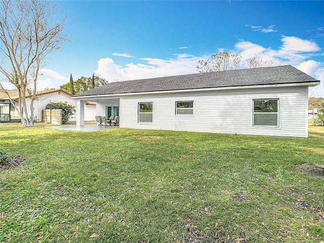 back of property with a lawn and a patio area