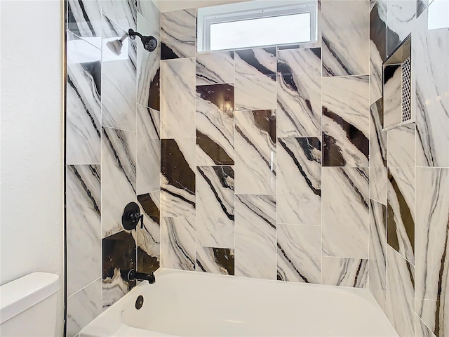 bathroom featuring shower / bathtub combination and toilet