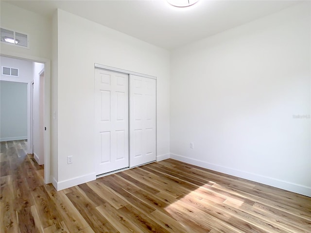 unfurnished bedroom featuring a closet and light hardwood / wood-style flooring