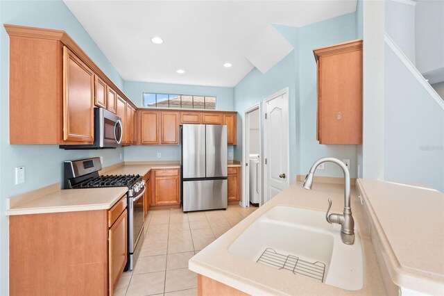 kitchen featuring stainless steel appliances, light tile patterned flooring, and sink