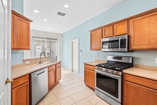 kitchen with sink, light tile patterned floors, and appliances with stainless steel finishes