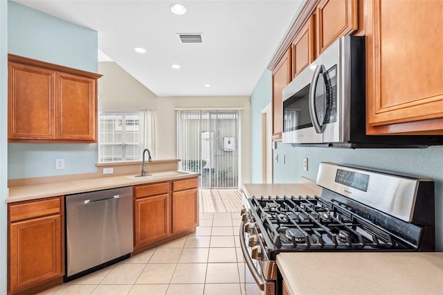 kitchen featuring stainless steel appliances, sink, and light tile patterned floors