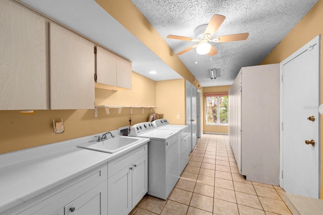 washroom with light tile patterned flooring, washer and dryer, sink, ceiling fan, and a textured ceiling