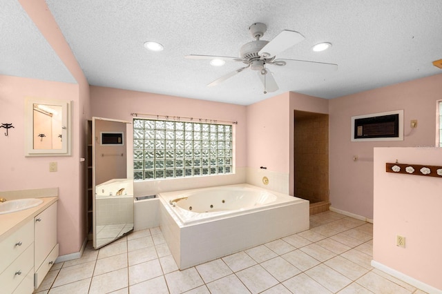 bathroom featuring tiled tub, ceiling fan, tile patterned flooring, vanity, and a textured ceiling