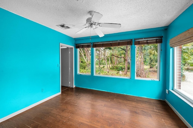 unfurnished room featuring a textured ceiling, dark wood-type flooring, and ceiling fan