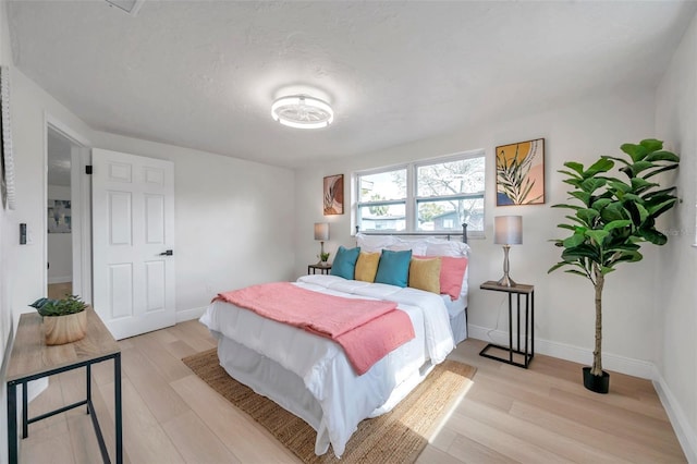 bedroom featuring a textured ceiling and light wood-type flooring