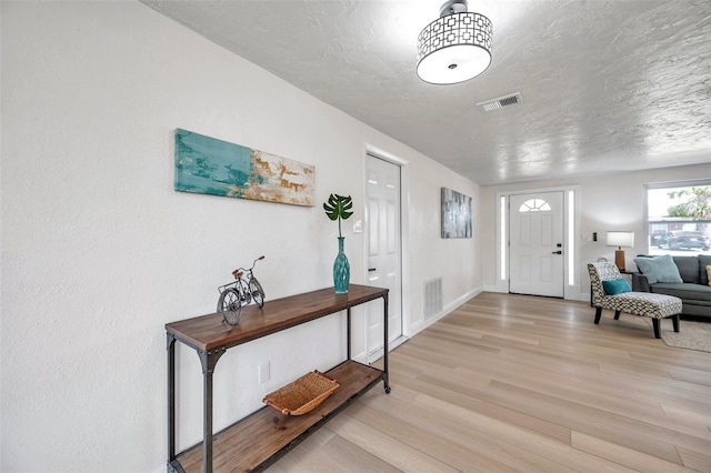 entrance foyer featuring a textured ceiling and light hardwood / wood-style flooring