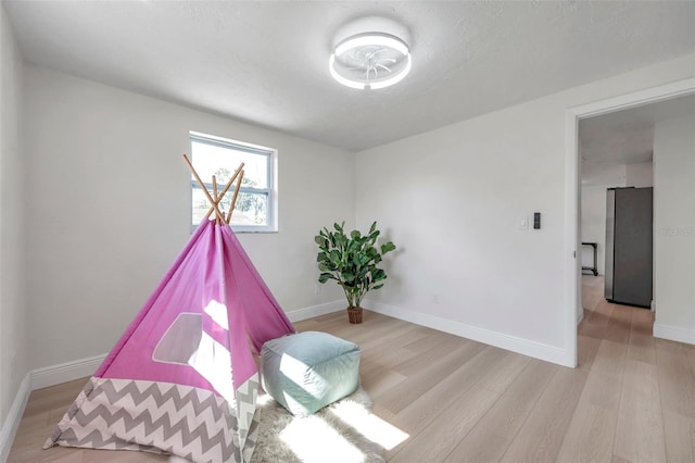 sitting room with a textured ceiling and light wood-type flooring