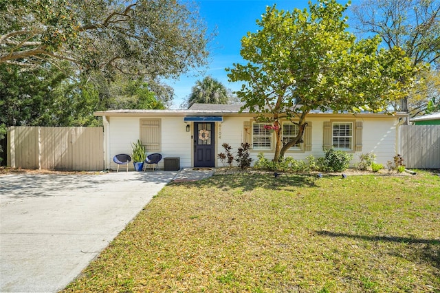 ranch-style home featuring fence and a front lawn