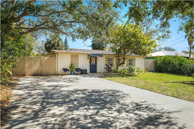 ranch-style home featuring fence and a front lawn