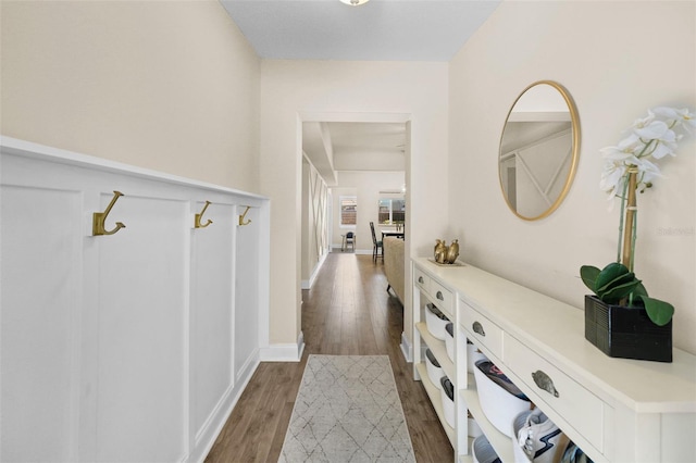 corridor featuring wood finished floors and baseboards