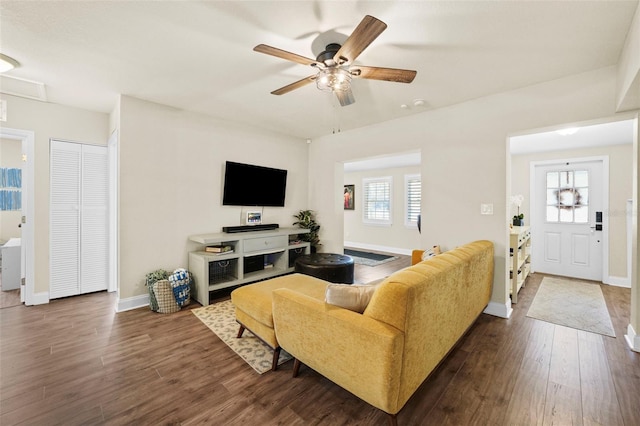 living room with a ceiling fan, plenty of natural light, baseboards, and dark wood-type flooring