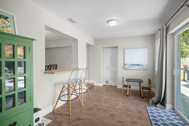 interior space with baseboards, visible vents, and wood finished floors