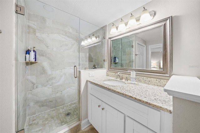 bathroom with a shower stall and vanity