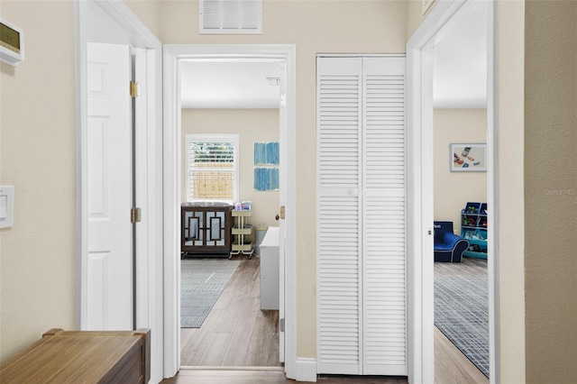 hallway featuring visible vents and wood finished floors