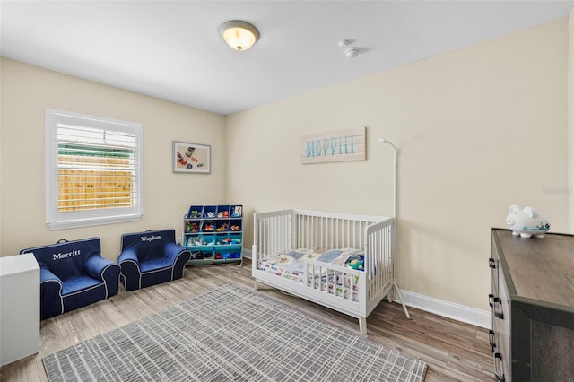 bedroom with wood finished floors and baseboards