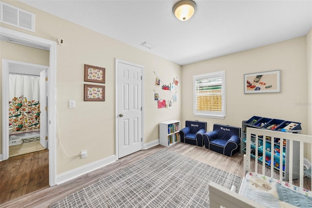 bedroom with visible vents, baseboards, and wood finished floors