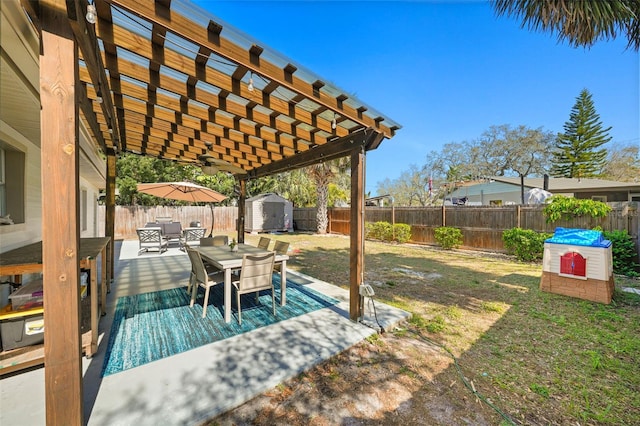 view of yard featuring an outbuilding, outdoor dining area, a shed, a pergola, and a fenced backyard