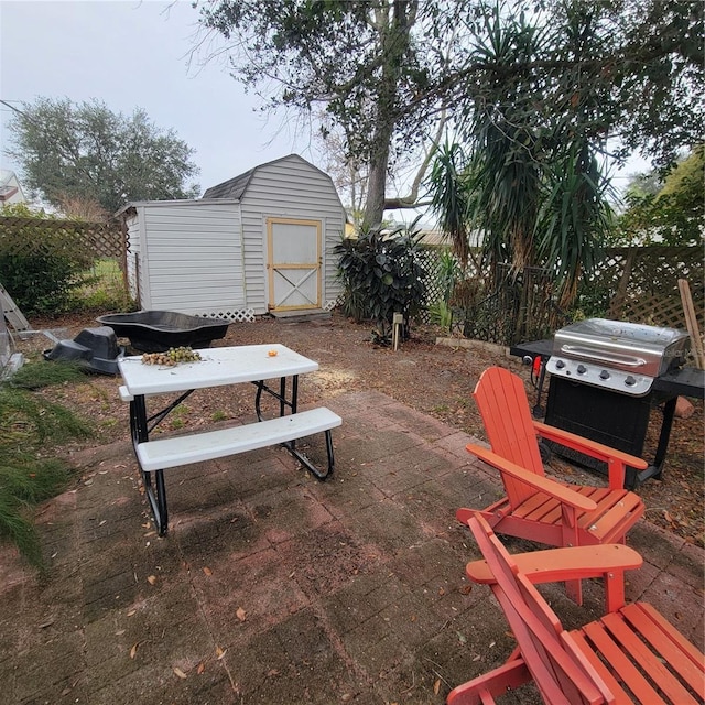 view of patio featuring a shed and area for grilling