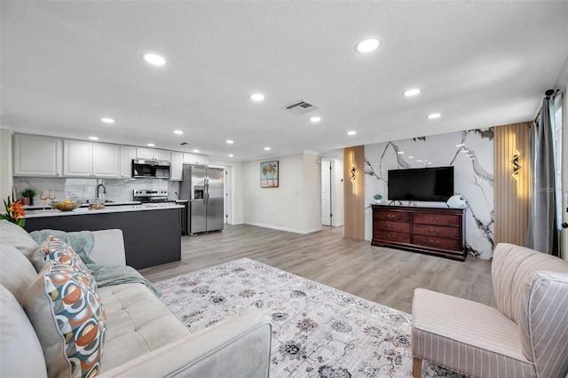 living room featuring sink and light wood-type flooring