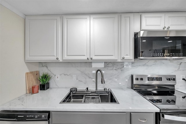 kitchen with white cabinetry, appliances with stainless steel finishes, sink, and backsplash