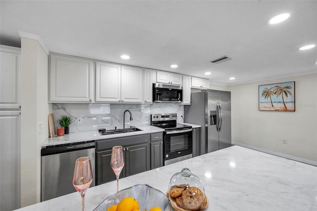 kitchen featuring sink, white cabinets, decorative backsplash, light stone counters, and stainless steel appliances