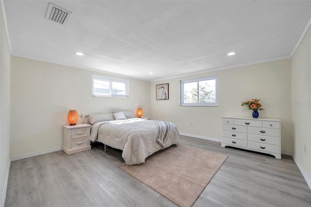 bedroom with light hardwood / wood-style flooring and ornamental molding