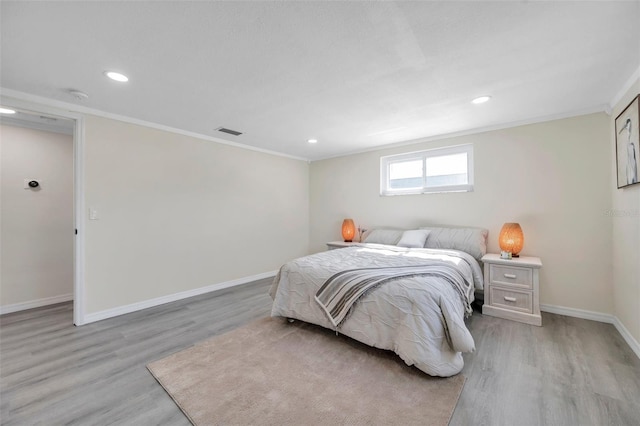 bedroom featuring ornamental molding and light hardwood / wood-style floors