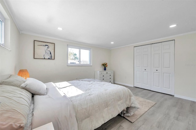 bedroom with crown molding, light hardwood / wood-style flooring, and a closet