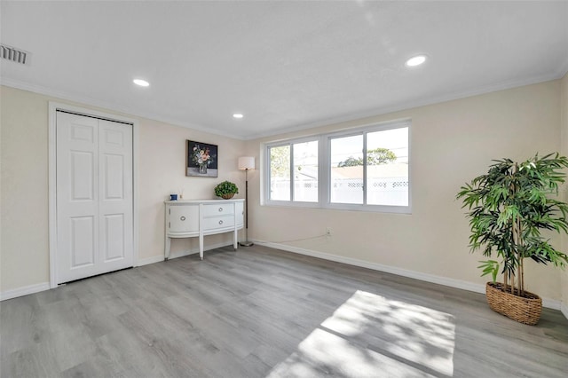 bedroom featuring ornamental molding, light hardwood / wood-style floors, and a closet