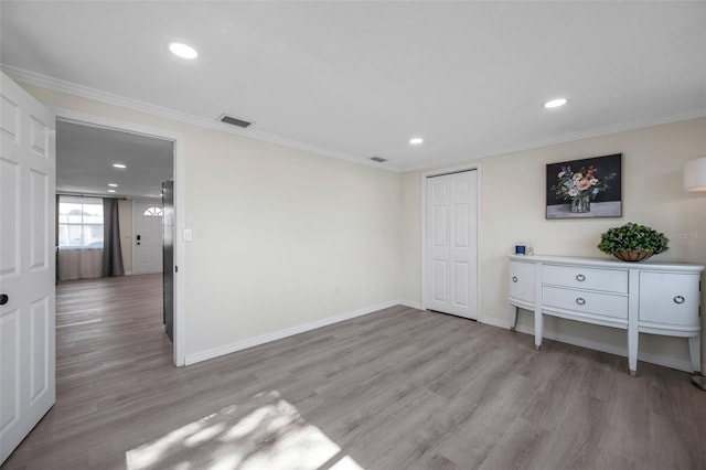 interior space featuring crown molding, a closet, and light hardwood / wood-style flooring