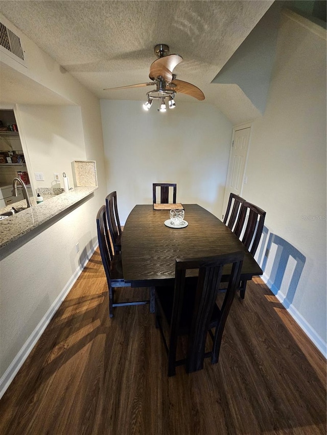 dining area featuring sink, dark hardwood / wood-style floors, a textured ceiling, and ceiling fan