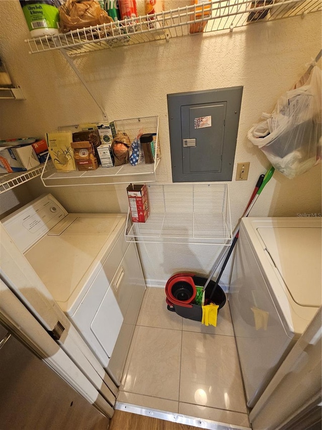 laundry room featuring washing machine and dryer, electric panel, and tile patterned floors