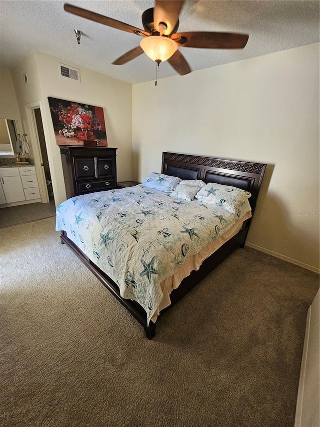 bedroom featuring ceiling fan, a textured ceiling, and dark colored carpet