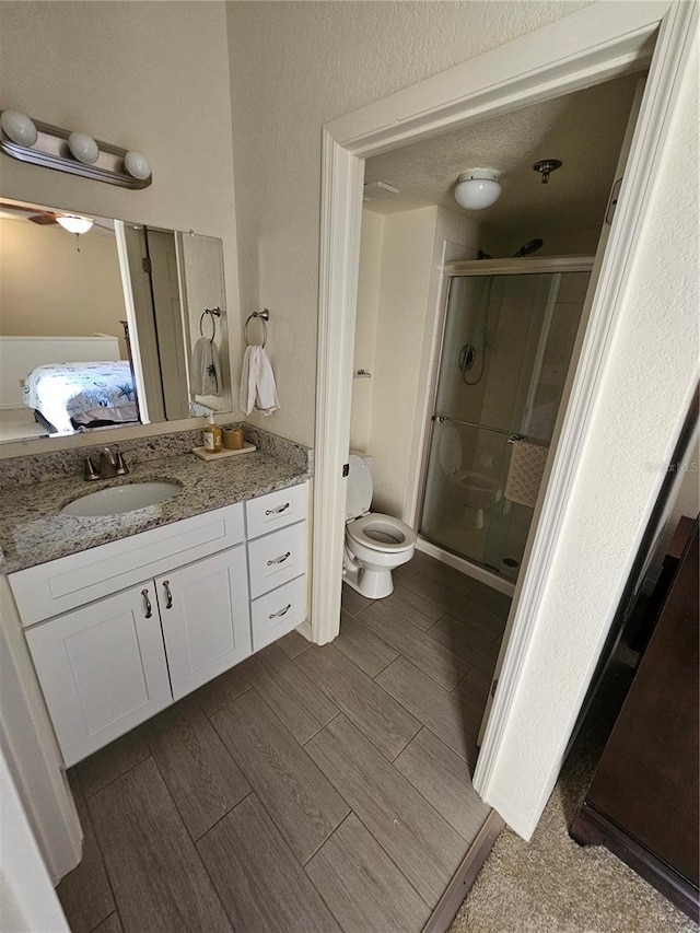 bathroom with vanity, toilet, and an enclosed shower