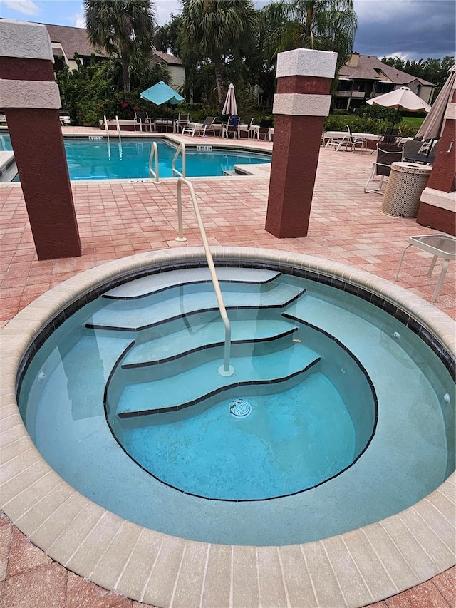 view of pool featuring a patio area and a hot tub