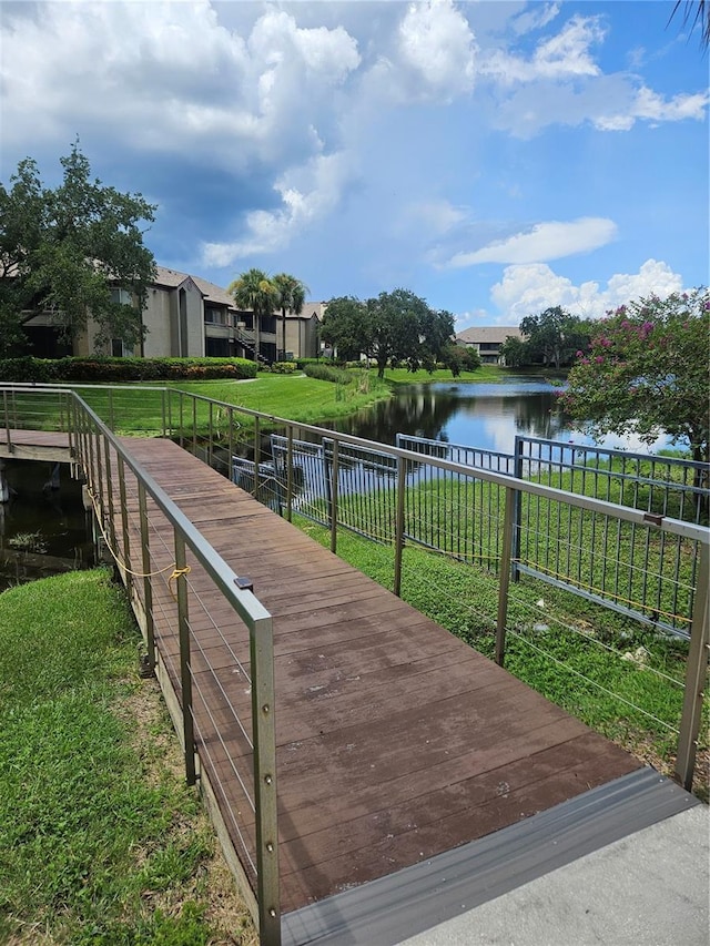 view of dock featuring a water view and a lawn