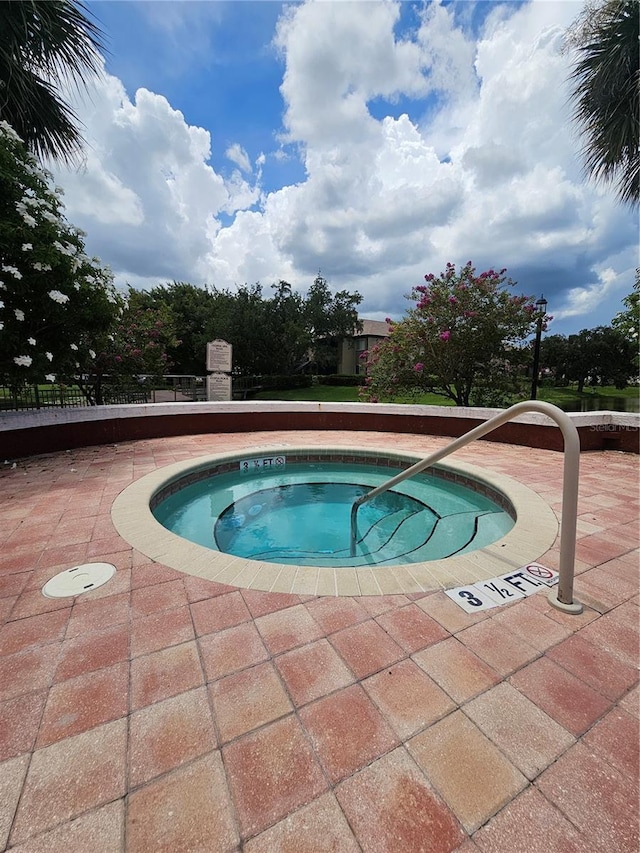 view of swimming pool with a hot tub and a patio