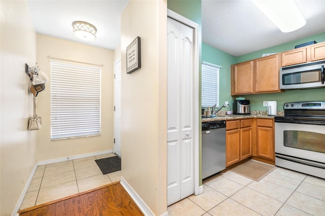 kitchen featuring stainless steel appliances, light tile patterned flooring, and sink