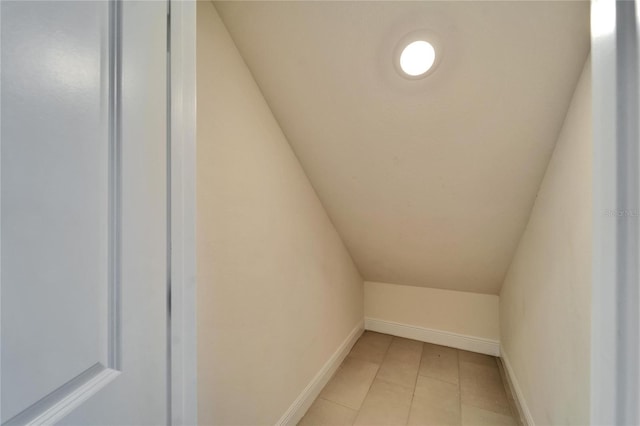 interior space featuring tile patterned flooring and lofted ceiling